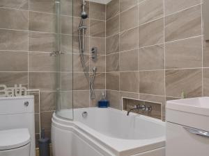 a bathroom with a tub and a toilet and a shower at Causey Pike in Keswick