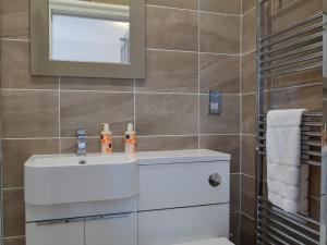a bathroom with a white sink and a mirror at Causey Pike in Keswick