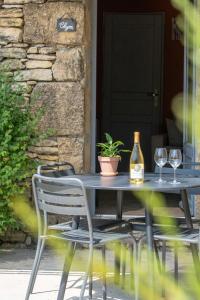 a table with two glasses and a bottle of wine at Le Bouquet de l Aromate in Joucas