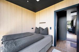 a bedroom with a large bed with wooden walls at Chalet Seewald - Tiny House in Seewald