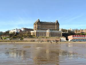 a large building sitting on top of a beach at Eldin Hall Cottage 1 - Uk2483 in Cayton +2 photos