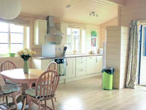 a kitchen with a table and a dining room at Skylark Lodge - Uk51678 in Carsethorn