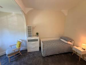 a small bedroom with a bed and a chair at 1 Bron Rhedyn Holiday Cottage in Betws-y-coed +2 photos