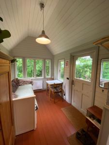a room with a table and a bed and windows at Fint Tiny house på Österlen in Sankt Olof