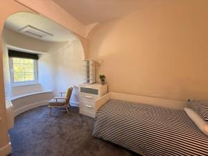 a bedroom with a bed and a desk and a chair at 1 Bron Rhedyn Holiday Cottage in Betws-y-coed