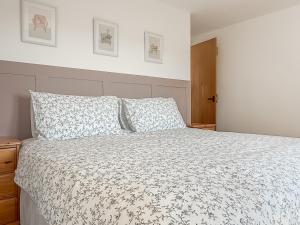 a bedroom with a bed with a white comforter at The Granary - Uk50171 in Mare Green