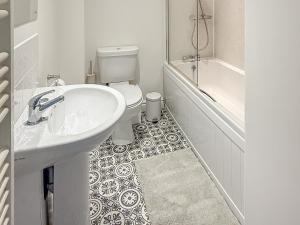 a white bathroom with a sink and a toilet at The Granary - Uk50171 in Mare Green