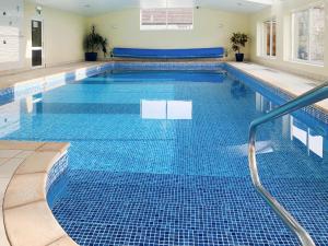 a large swimming pool with a blue tiled floor at The Granary - Uk50171 in Mare Green