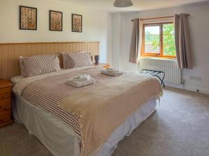 a bedroom with a large bed with two towels on it at The Swallows - Uk50177 in Mare Green