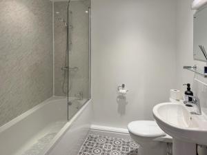 a white bathroom with a shower and a sink at The Swallows - Uk50177 in Mare Green