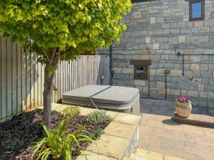 a mattress sitting on a patio next to a tree at The Swallows - Uk50177 in Mare Green
