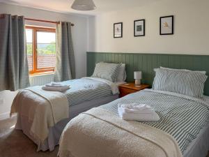 two beds sitting next to each other in a bedroom at The Swallows - Uk50177 in Mare Green