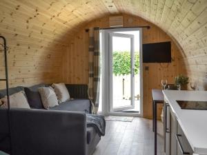 a living room with a couch and an open door at Sycamore - Uk47621 in Hunmanby
