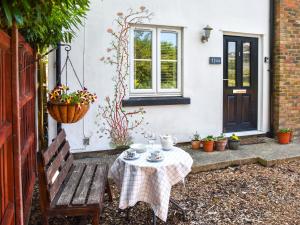 a table and a bench in front of a house at Riverside in March