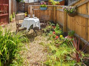 a patio with a table and chairs in a garden at Riverside in March