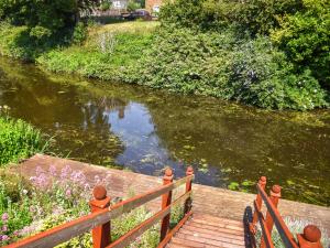 a wooden bridge over a river with flowers and a river at Riverside in March +20 photos