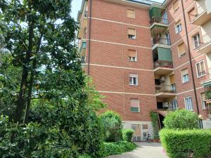 a large brick building with trees in front of it at Oxi in Modena