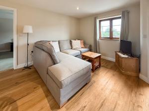 a living room with a couch and a television at The Wrens - Uk50181 in Mare Green