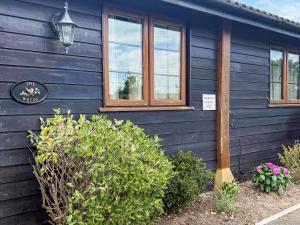 a blue house with windows and a sign on it at The Wrens - Uk50181 in Mare Green