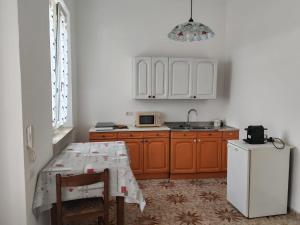 a kitchen with a table and a white refrigerator at San bernardo guest house in Fossano