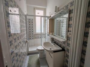a bathroom with a sink and a toilet and a mirror at San bernardo guest house in Fossano