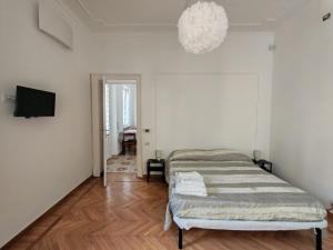 a bedroom with a bed and a television and a chandelier at San bernardo guest house in Fossano