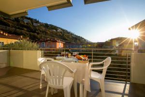 a table and chairs on a balcony with a view at Torbole Relax, Pool & Balcony Apartment in Nago-Torbole