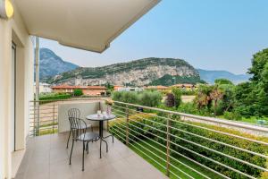 a balcony with a table and chairs and a view at Torbole Relax, Pool & Balcony Apartment in Nago-Torbole