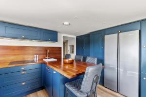 a kitchen with blue cabinets and a wooden counter top at John Brown Cottage in Skipton