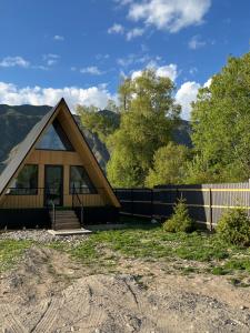 a home with a gambrel roof and a fence at Kolsay A-Frame Yessen in Saty