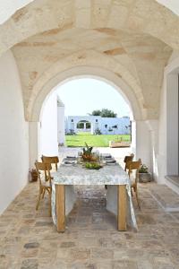 a dining room with a white table and chairs at Corte di Torre Spaccata in Torre Canne