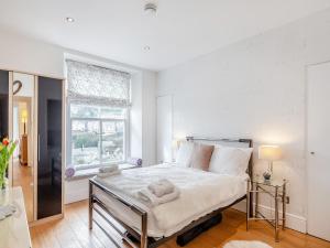 a bedroom with a large bed with towels on it at Gwendrock Diw in Looe