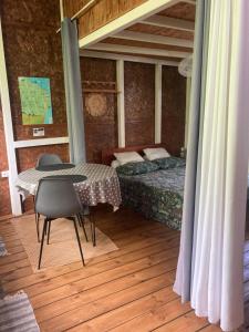 a bedroom with a bed and a table with a chair at Eden des laves in Sainte-Rose +13 photos
