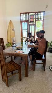 a group of men sitting at a table at Robbo's Surfcamp in Arugam Bay