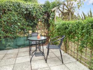 a table and two chairs sitting next to a fence at Elm Loft in Upton