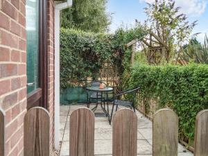 a patio with a table and chairs in a garden at Elm Loft in Upton