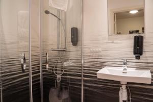 a bathroom with a shower and a sink at Hotell TunaPark in Eskilstuna +37 photos