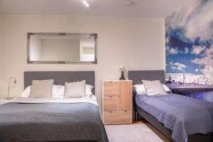 a bedroom with two beds and a mirror on the wall at Hotell TunaPark in Eskilstuna