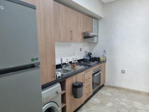 a small kitchen with a sink and a dishwasher at Central Park in Mohammedia