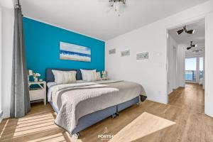 a bedroom with a bed with a blue wall at Ferienhaus Hamptons Beach House Olpenitz in Olpenitz