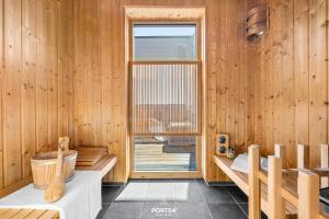 a wooden room with a tub and a window at Ferienhaus Hamptons Beach House Olpenitz in Olpenitz