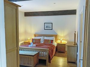 a bedroom with a bed and two night stands and two lamps at Murton Cottage in East Ord