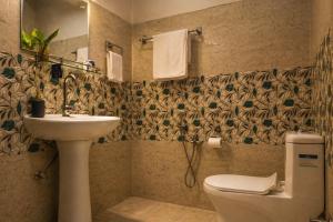 ein Badezimmer mit Toilette und Waschbecken in der Unterkunft Bononi in Jorhat + 71 Fotos