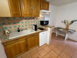 a kitchen with a sink and a microwave at Studio in Fayence