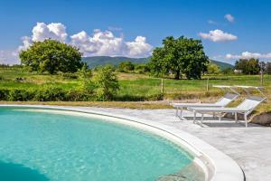 a swimming pool with two chairs and a table at Il Casale di Zoe in Sorano