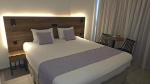 a bedroom with a large bed with a wooden headboard at Shalos Studios - Cozy Central in Ayia Napa