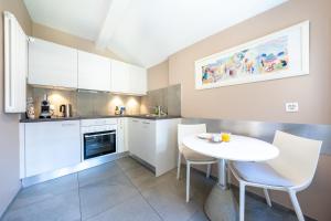 a small kitchen with a white table and chairs at Residenza Motta - Boutique Apartments in Locarno