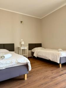 a bedroom with two beds and a wooden floor at Villa Sobótka in Sobótka +40 photos