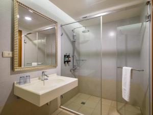 a bathroom with a sink and a glass shower at West Hotel in Puli +51 photos