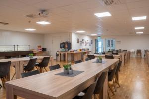 a large room with wooden tables and chairs at Hotell TunaPark in Eskilstuna
